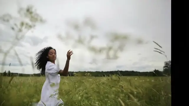 Mulher de vestido branco em um campo verde.